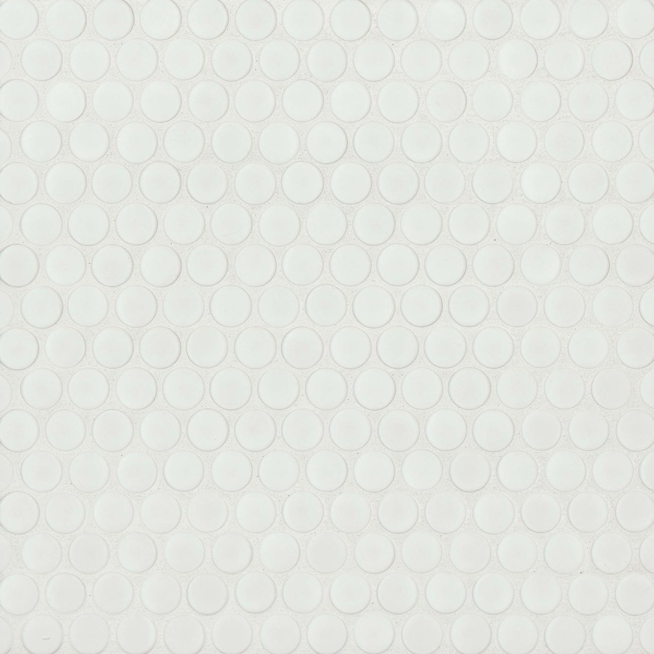 Matte white penny shaped mosaic tile on a beige background.