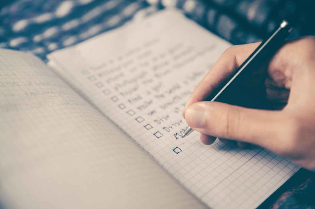 Photo of person writing a checklist in a journal