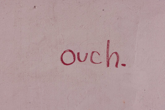 Word Ouch Written in Crayon on a Pink Piece of Paper