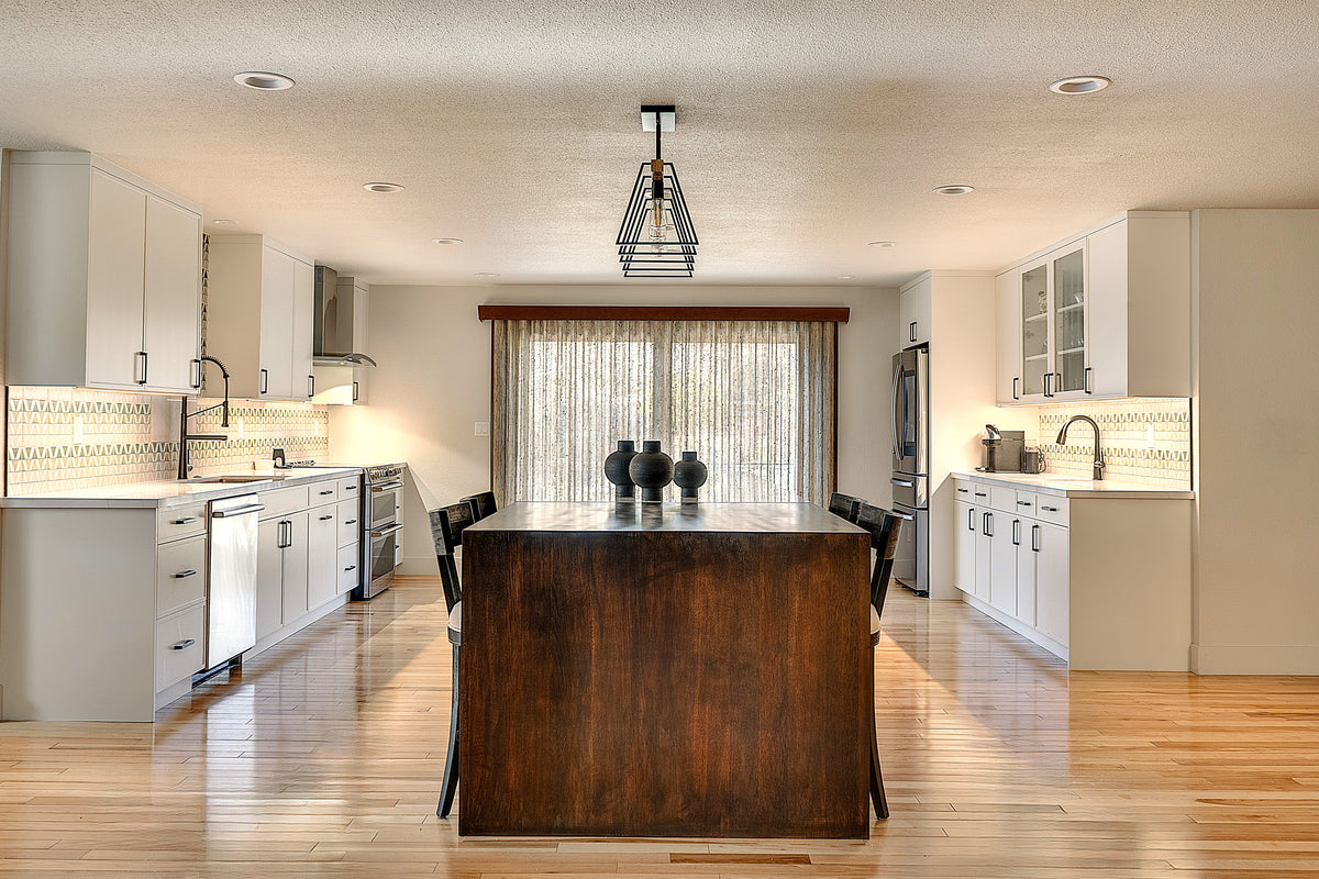 Modern mountain kitchen with wood waterfall island end and white painted perimter cabinets and stainless steel appliances