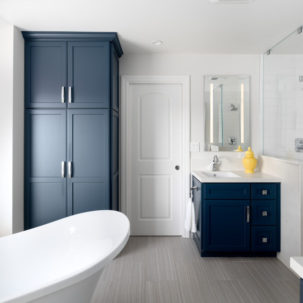Remodeled_Master_Bathroom_with_Freestanding_Tub_and_Custom_Navy_Blue_Vanity_and_Linen_Cabinets_Gray_Floor