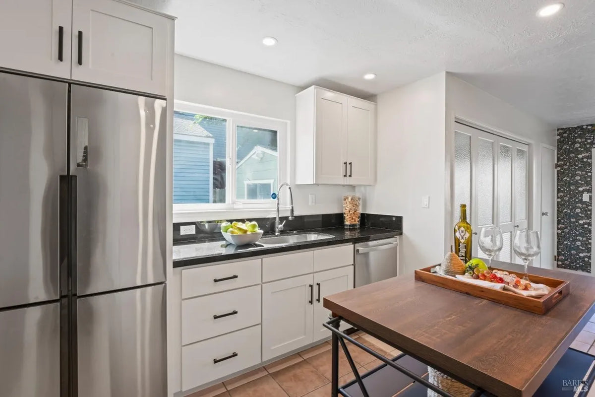 Modern kitchen with stainless steel appliances and a wooden island.