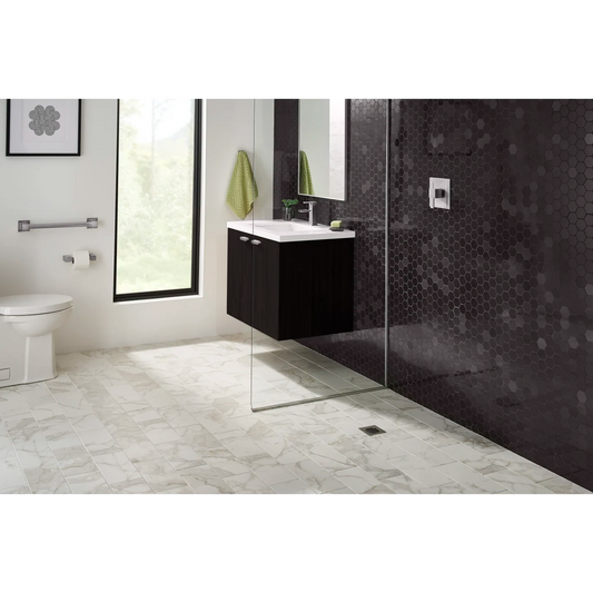 Black hexagon mosaic tile lining the shower and vanity wall with off-white, veined, marble floor. 