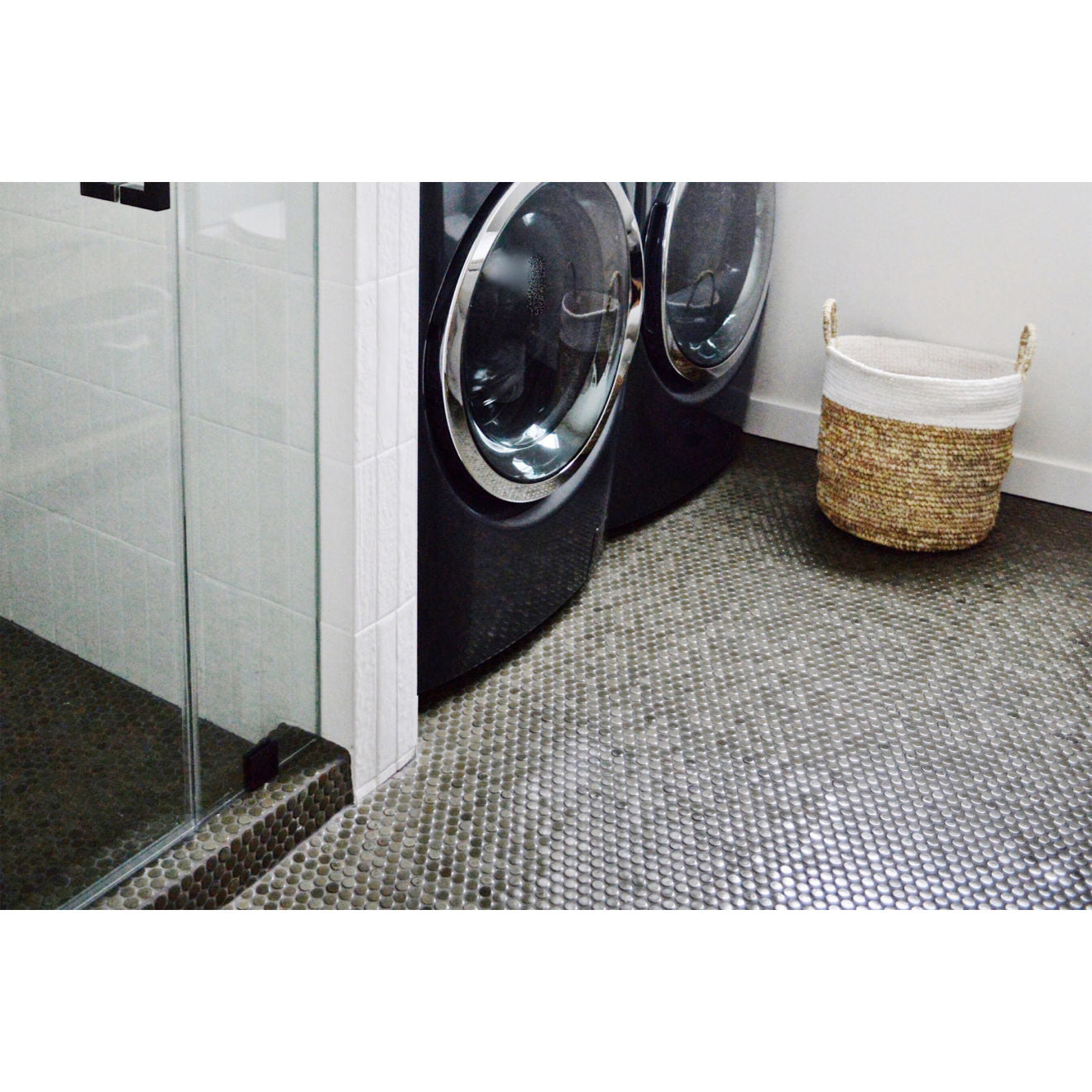 Pumice and charcoal penny round tiles lining the laundry room and shower floor.