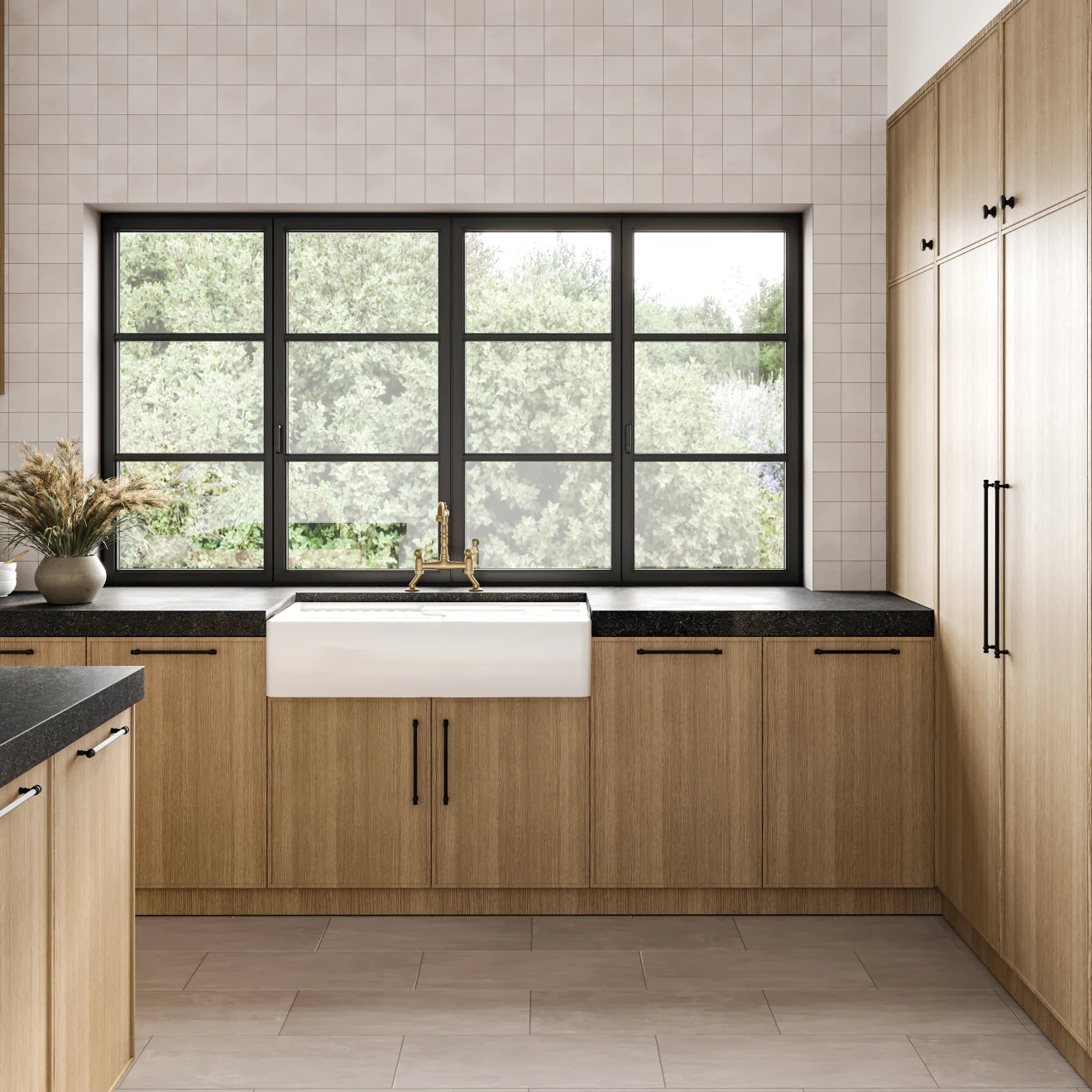 Black granite countertop in modern, minimalistic kitchen with light brown cabinets. 