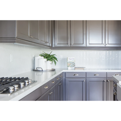 White and brown kitchen with Herringbone tile in the color White as a backsplash.