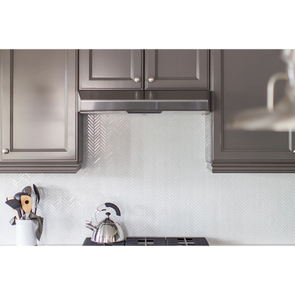 White and brown kitchen with Herringbone tile in the color White as a backsplash.