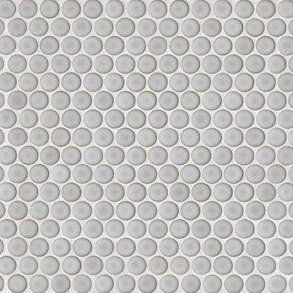 Dove grey penny shaped mosaic tile on a beige background.