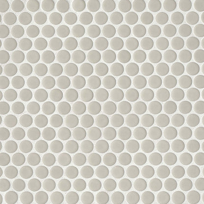 Off white penny shaped mosaic tile on a beige background.