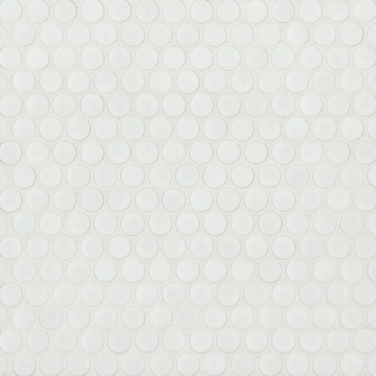 Matte white penny shaped mosaic tile on a beige background.