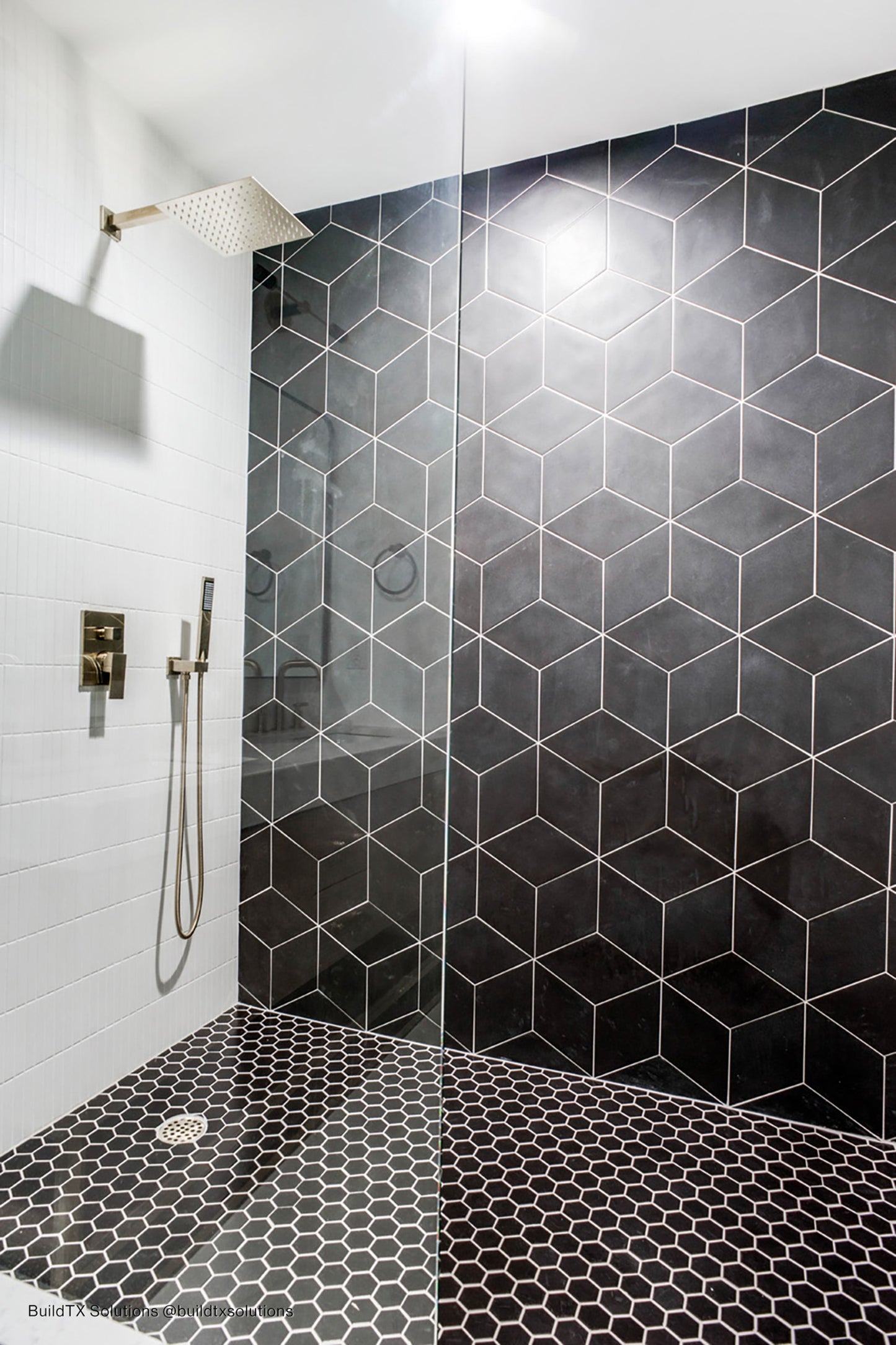 Accent wall in bathroom shower made of black rhomboid field tile